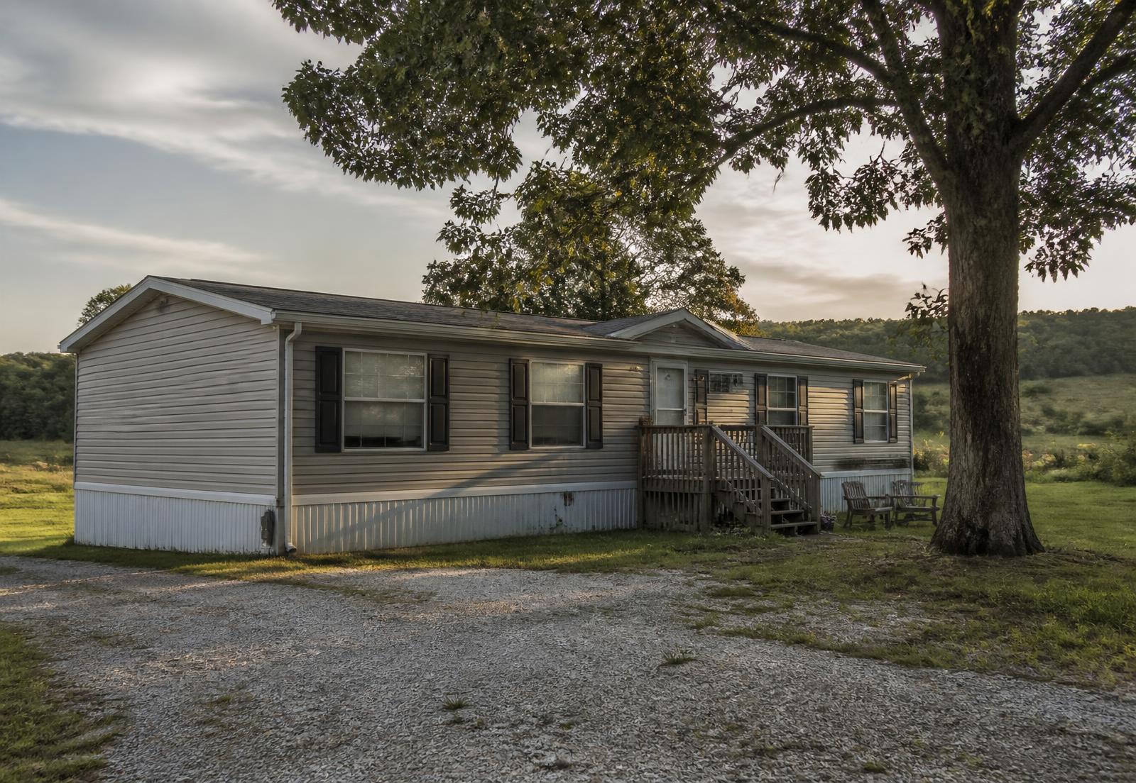 A single-wide manufactured home on a gravel lot in rural Missouri